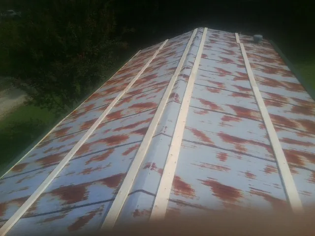 Rusted metal roof panels with new wood purlins before replacement — Storm Damage Roof Repair in Albany by Roofing Brothers
